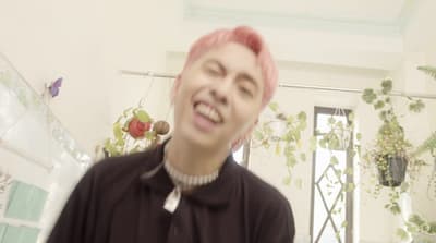 a person with pink hair standing in a room