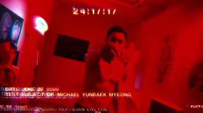 a man standing in a room with a red light