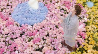 a woman standing in a field of flowers