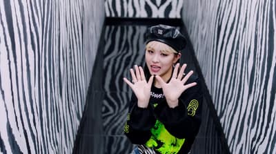 a woman standing in front of a zebra print wall