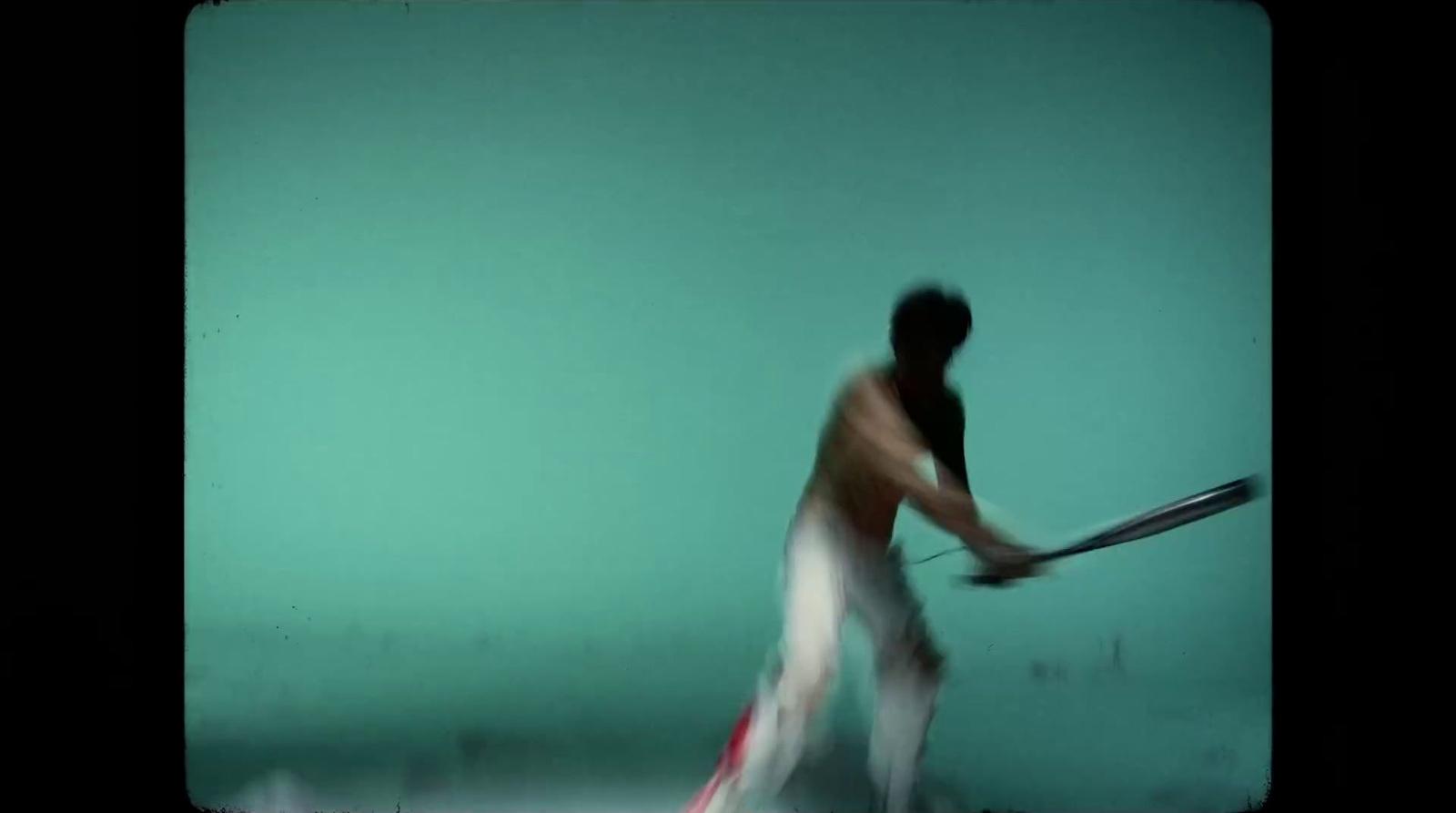 a blurry image of a man holding a tennis racquet