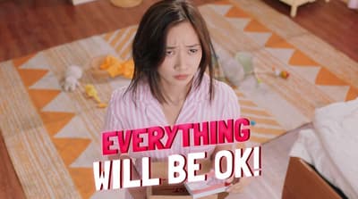 a woman holding a box with the words everything will be ok