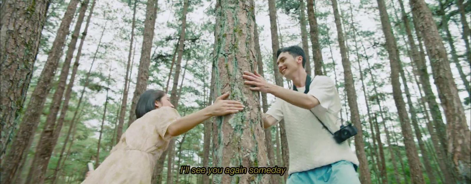 a man and a woman standing in the middle of a forest