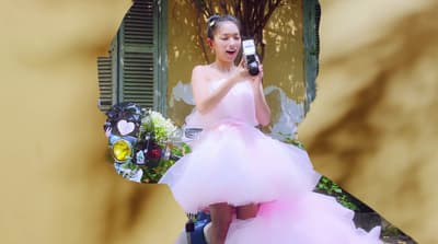 a woman in a pink dress holding a cell phone