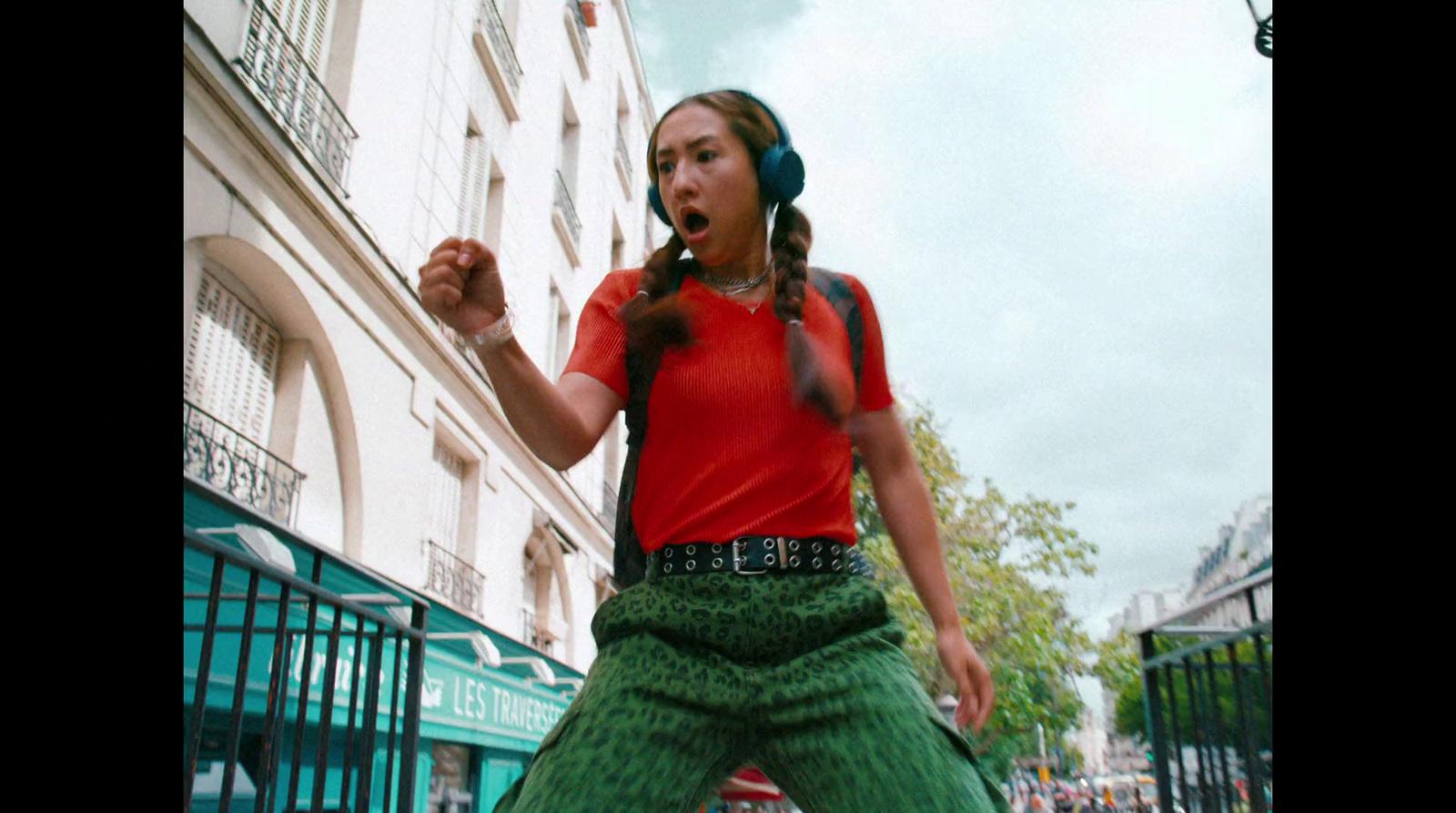 a woman with headphones standing in front of a building