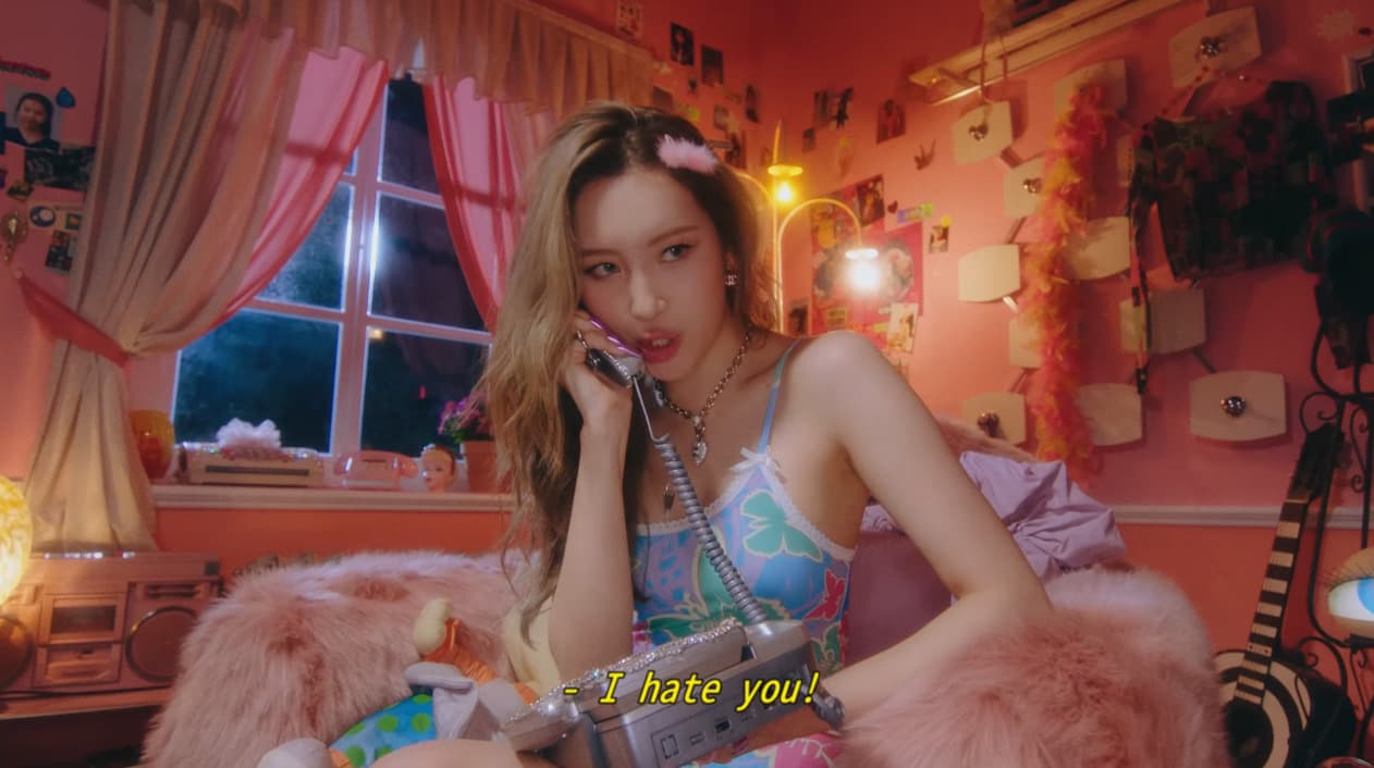 a woman sitting on a bed talking on a phone