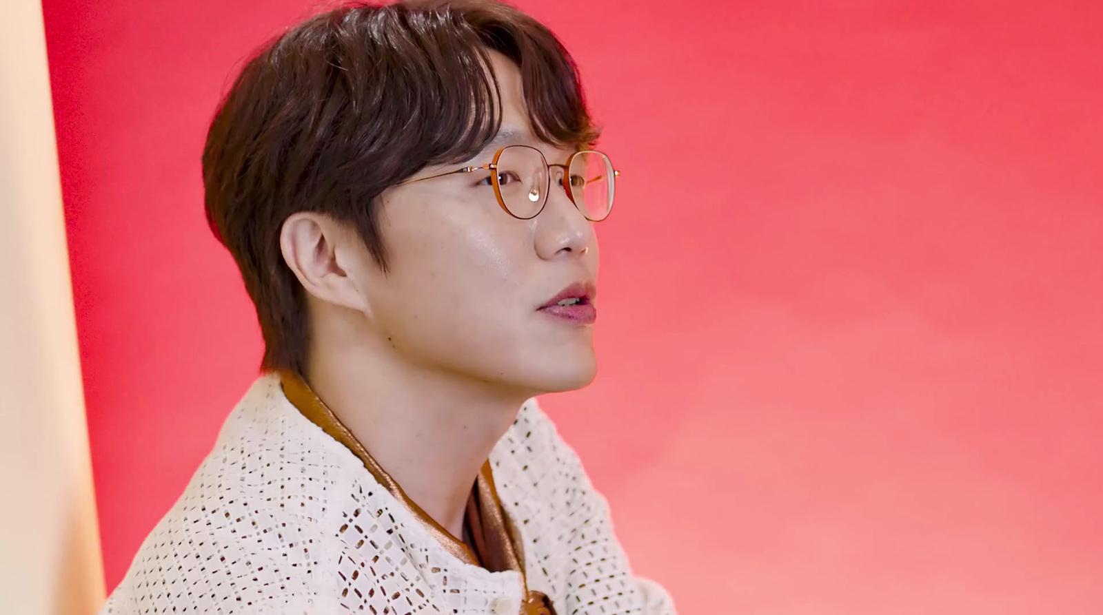 a young man wearing glasses and a sweater
