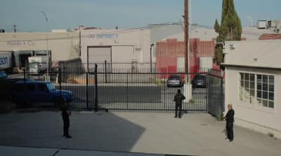 a couple of men standing in front of a fence