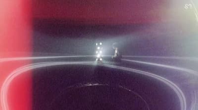 a car driving down a road at night
