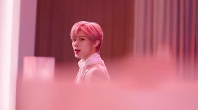 a person with pink hair and a white shirt