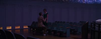 a man and a woman standing in front of a stage