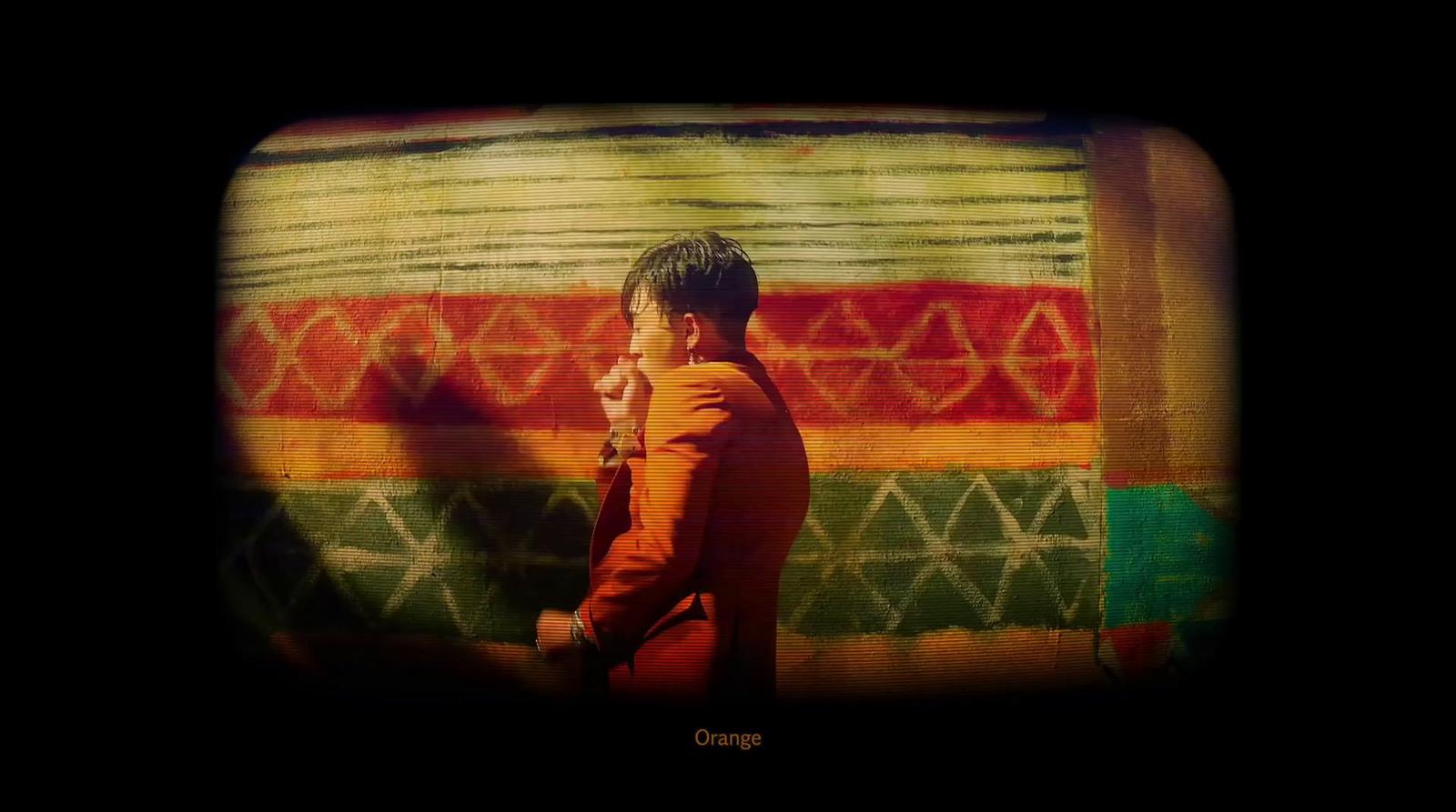 a young boy standing in front of a colorful wall