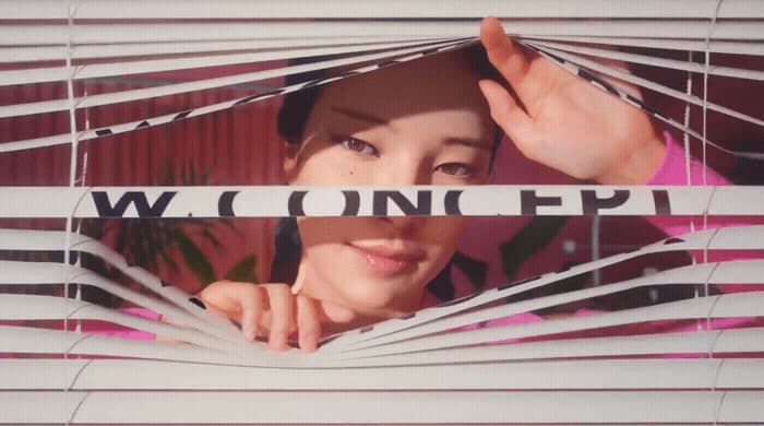 a woman looking through a window with blinds