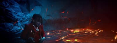a man standing in front of a fire filled cave