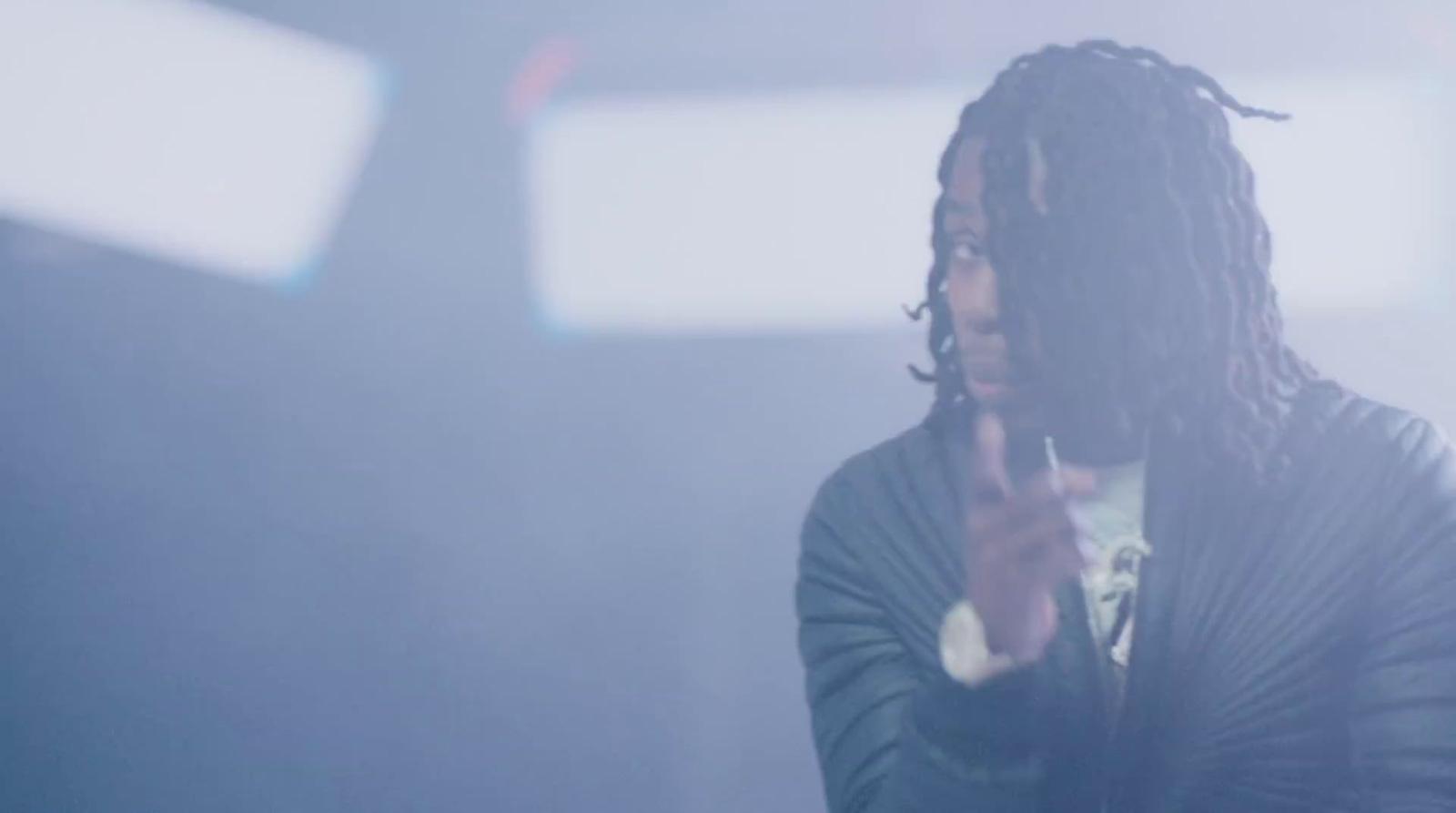 a man with dreadlocks holding a cell phone