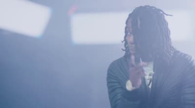 a man with dreadlocks holding a cell phone