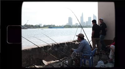 a group of men standing next to a body of water