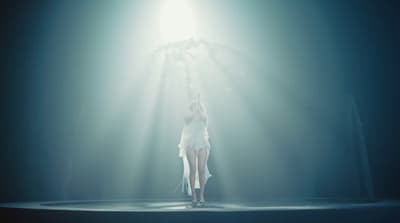 a woman in a white dress standing on a stage
