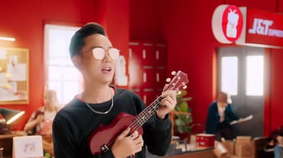 a young man holding a red guitar in a red room