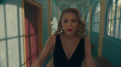 a woman in a black dress standing in a hallway