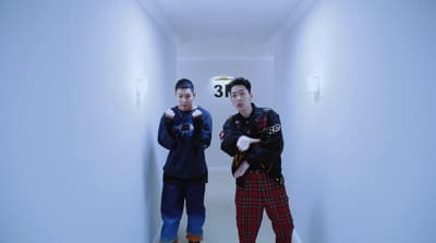 a couple of men standing in a hallway next to each other