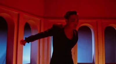 a woman standing in a room with a red light