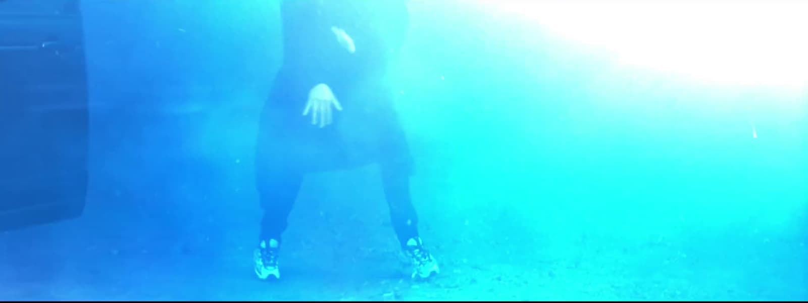 a woman in a black dress standing in the water