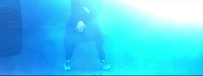 a woman in a black dress standing in the water