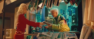 a woman handing a man something in a store