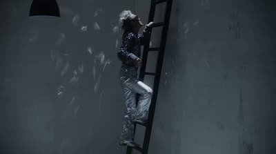 a person standing on a ladder in a room