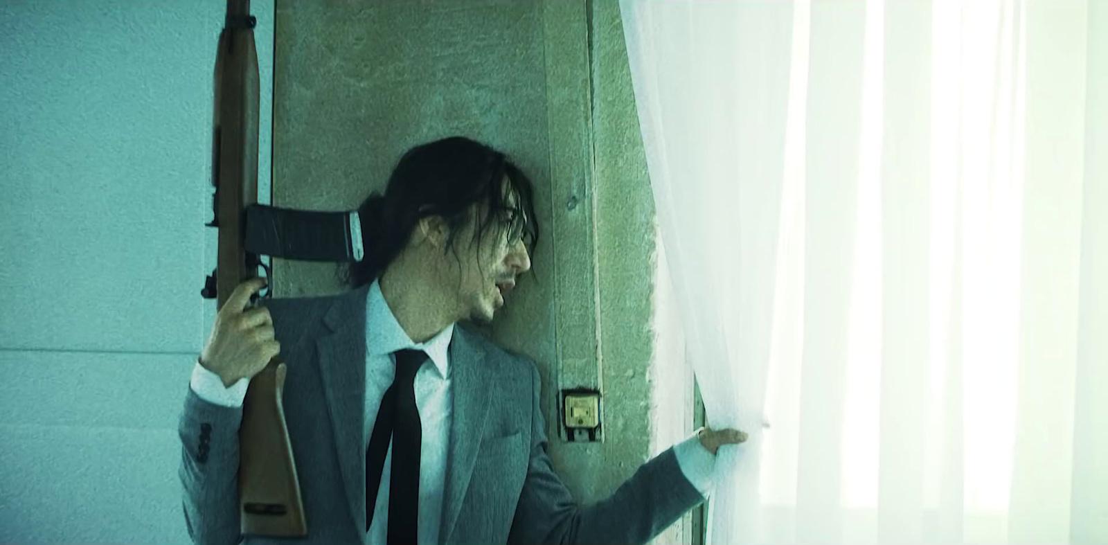 a man in a suit and tie holding a rifle