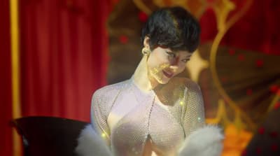 a woman in a white dress with feathers around her neck