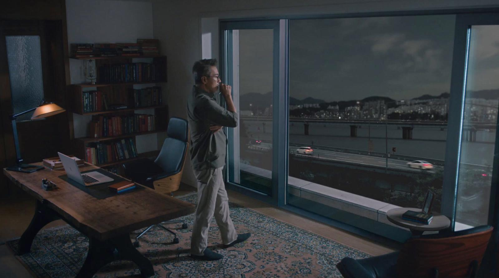 a man standing in a room next to a window
