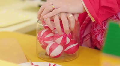 a close up of a person putting candy in a jar
