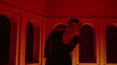 a woman standing in front of a red light