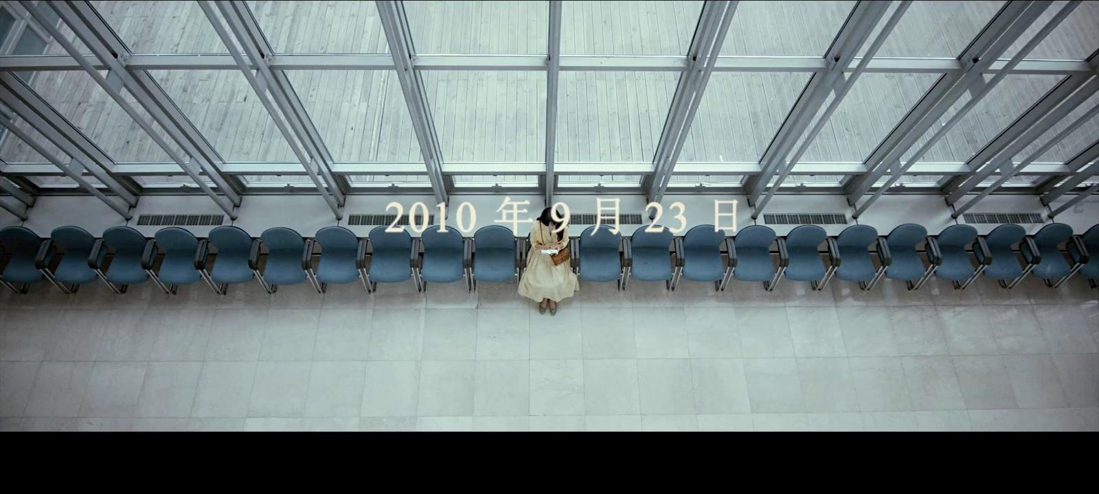 a woman standing in front of a group of blue chairs