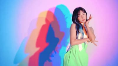 a woman standing in front of a colorful wall