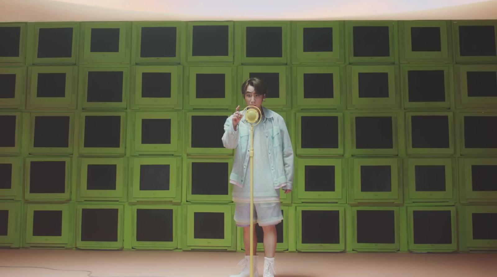 a woman standing in front of a green wall
