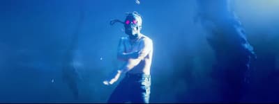a man with a mask and goggles standing in the dark