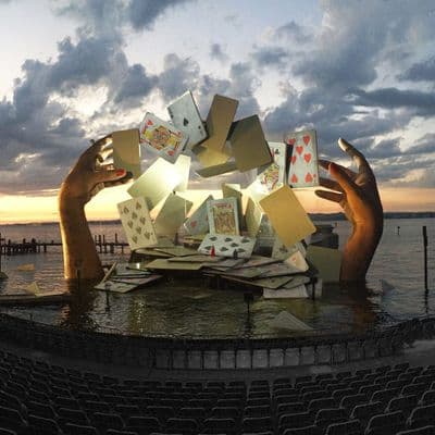 a sculpture of playing cards in the middle of a body of water