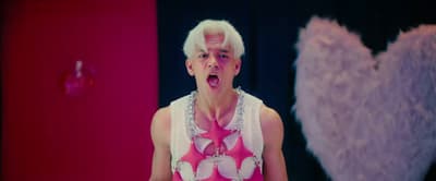 a man with white hair wearing a pink shirt