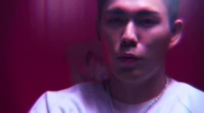 a man in a white shirt and a necklace