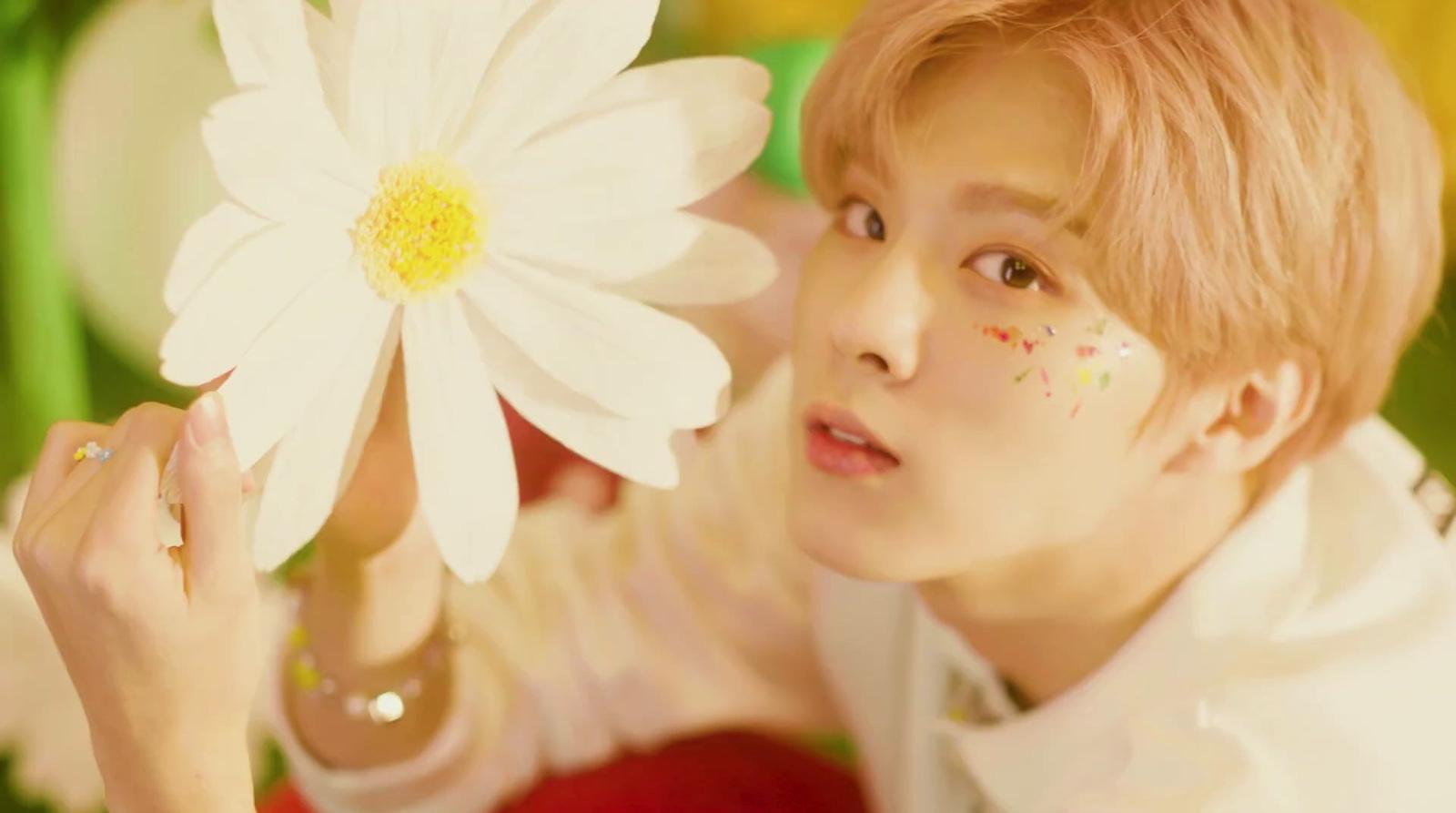 a person holding a flower in front of their face