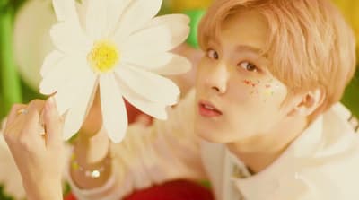 a person holding a flower in front of their face