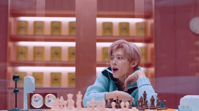 a woman sitting at a table playing a game of chess