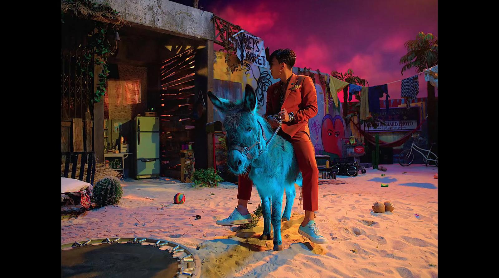 a man standing on top of a blue donkey