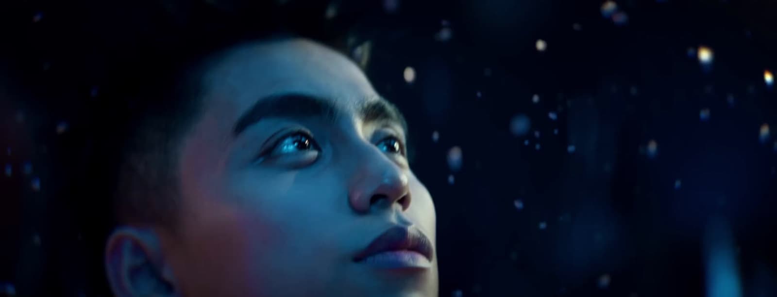 a young man looking out of a window in the rain