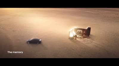 a car and a house in the middle of a desert