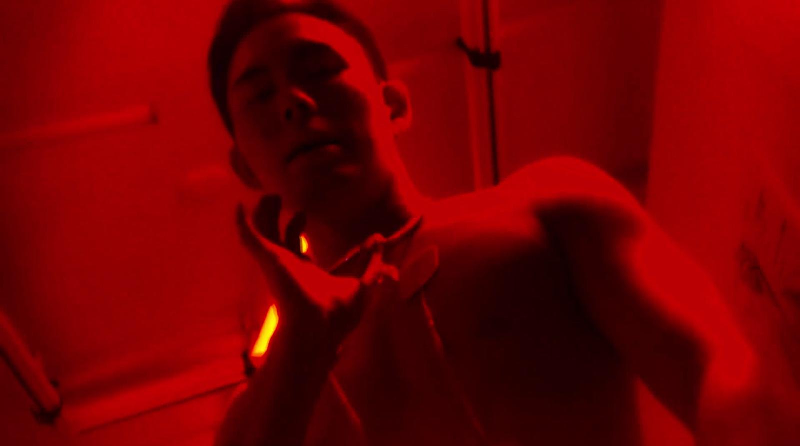 a man standing in a bathroom with a red light