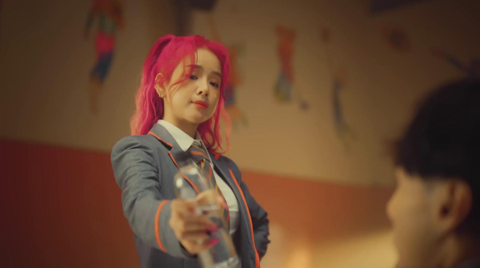 a woman with pink hair is holding a glass